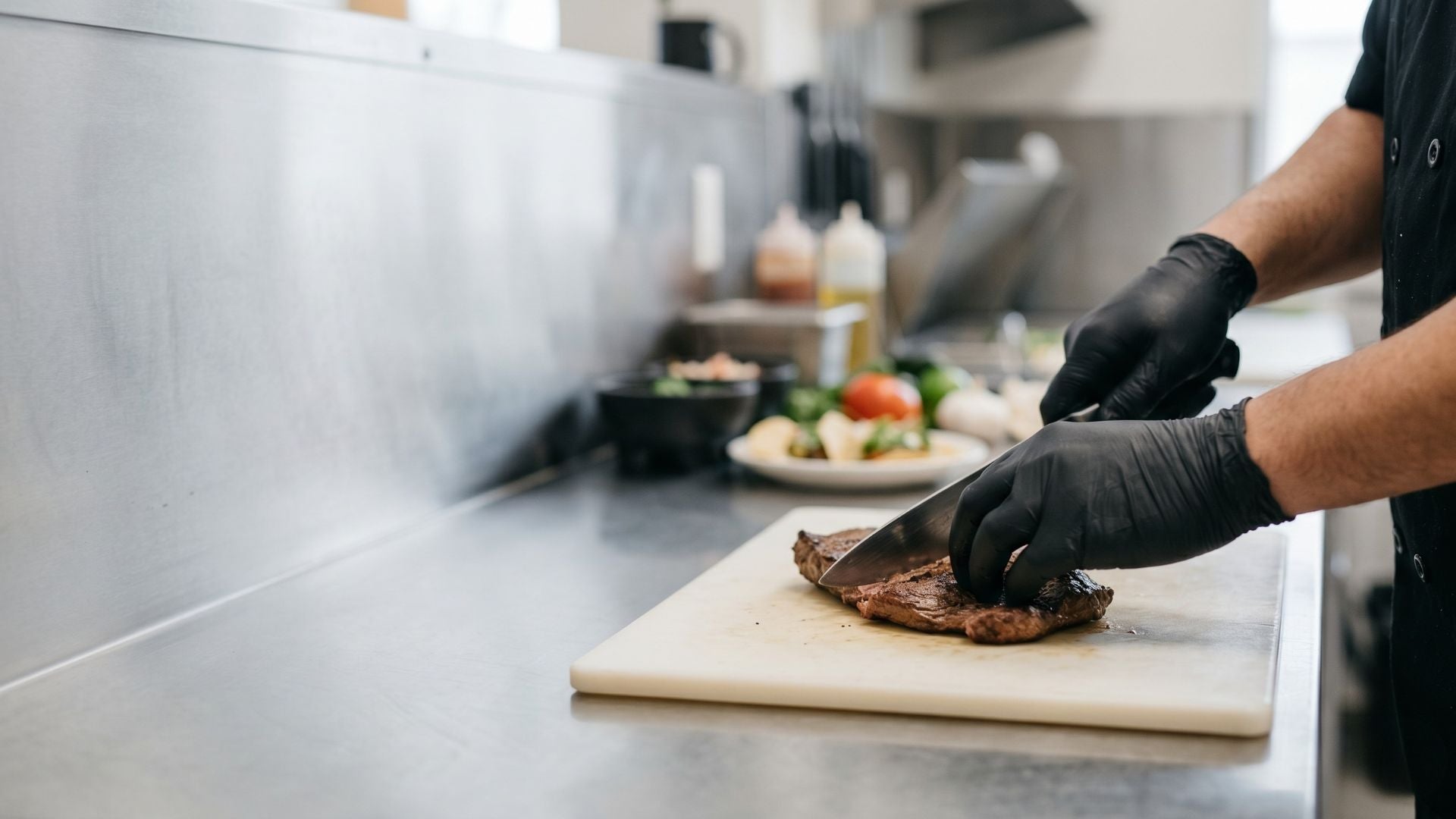 Chef preparando alimentos con guantes de nitrilo negros en cocina profesional en México, uso seguro y apto para manipulación de alimentos